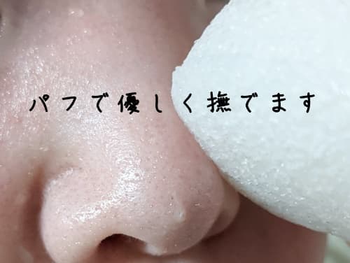 水を含ませたこんにゃくパフで顔をなでる